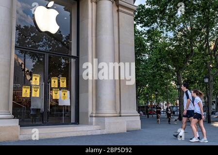 Barcellona, Spagna. 17 maggio 2020. Due persone si avvicinano all'Apple Store per leggere i cartelli apparsi sulla porta. Il gruppo ambientale noto come la ribellione estinzione di Barcellona ha eseguito un'azione con i poster apparsi sulla porta del negozio di bandiere di Apple Inc. Durante il Covid-19. Credit: SOPA Images Limited/Alamy Live News Foto Stock