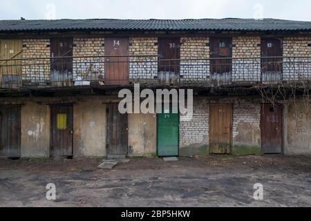 Una fila, sezione di armadietti di mattoni di deposito garage sul retro di un vecchio edificio di appartamenti nella Città Vecchia. A Vilnius, Lituania. Foto Stock