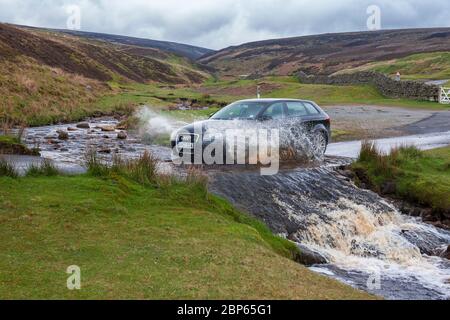 L'auto passa attraverso il ford a Fore Gill Gate, Reeth Moor, North Yorkshire, Inghilterra: presentato nella serie TV "All Creatures Great and Small" Foto Stock