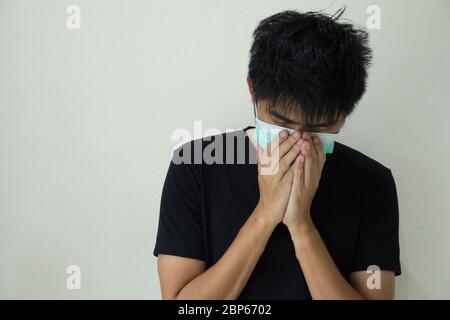 Giovane uomo che si sente malato e indossa la maschera facciale Foto Stock