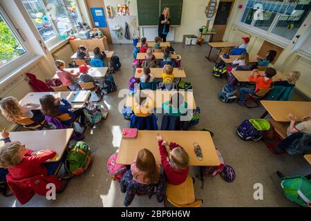 Dresda, Germania. 18 maggio 2020. Gli allievi di una prima classe elementare sono seduti in classe. Dal 18.05.2020 in poi, le scuole elementari in Sassonia saranno nuovamente aperte in condizioni di funzionamento limitato e regolare per tutti i bambini dopo settimane di pausa obbligatoria a causa della pandemia della corona. Credit: Robert Michael/dpa-Zentralbild/dpa/Alamy Live News Foto Stock