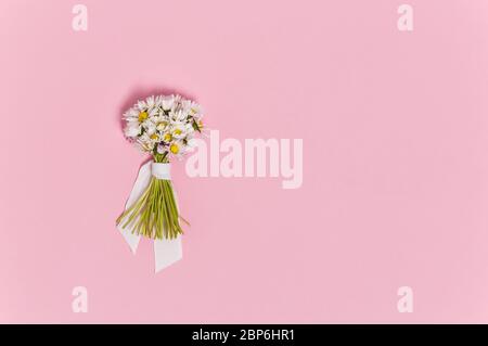 Romantico bouquet di teneri fiori margherita su sfondo rosa dall'alto. Biglietto di auguri per compleanno, matrimonio o giorno della madre. Vista dall'alto, disposizione piatta con c Foto Stock