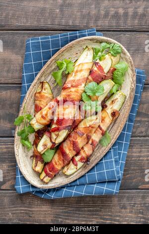 Patate fritte grigliate di zucchine avvolte in una pancetta Foto Stock