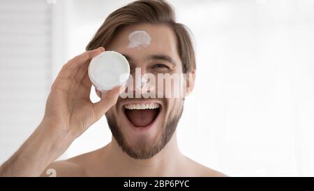 Ritratto di giovane sorridente consiglia crema facciale Foto Stock
