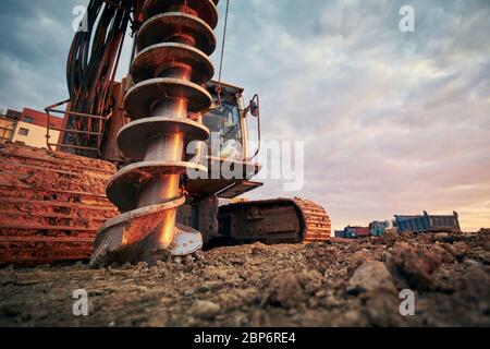 Attività di costruzione sul sito di costruzione. Vista ravvicinata della macchina perforatrice contro i carrelli. Foto Stock