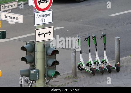 Quattro scooters e-scooters completamente caricati di Lime parcheggiati ordinatamente da Lime Juicer sul marciapiede a Berlino NeukÃ¶lln all'angolo HermannstraÃŸe SilbersteinstraÃŸe per l'uso. Foto Stock