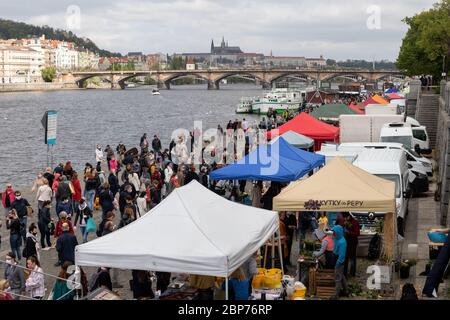 PRAGA, REPUBBLICA CECA - 25 APRILE 2020: Persone in maschere di faccia shopping al mercato agricolo di Naplavka riaperto Foto Stock