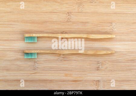 Set di due spazzolini da denti in bambù su sfondo di legno. Zero rifiuti, materiale biodegradabile, concetto ambientale Foto Stock