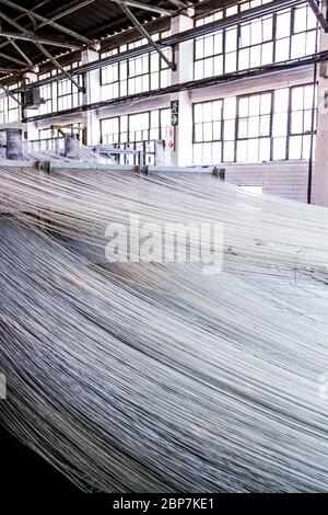 Johannesburg, Sudafrica - 16 ottobre 2012: Linee di filo di cotone per un telaio della linea di assemblaggio della trama dell'avvolgitore Foto Stock