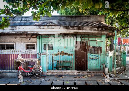 Una vecchia casa una volta usata come lavanderia in rovina a Angeles City Filippine. Foto Stock