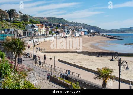 Lyme Regis, Dorset, Regno Unito. 18 maggio 2020. Regno Unito Meteo: Un caldo e soleggiato inizio della settimana presso la pittoresca località balneare di Lyme Regis. La gente gode della mini-ondata di calore durante la pandemia del coronavirus dopo l'allentamento delle restrizioni di blocco la settimana scorsa. Credit: Celia McMahon/Alamy Live News Foto Stock