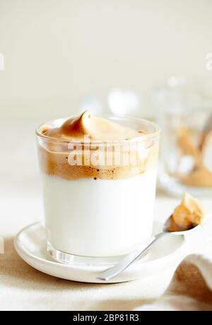 Bevanda coreana alla moda montata con schiuma di caffè istantaneo su sfondo beige primo piano fuoco selettivo Foto Stock