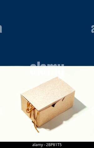 Pacchetto eco box di carta e bastoncini di carta su sfondo blu e bianco. Concetto creativo di consegna ristorante e cibo asiatico da asporto Foto Stock