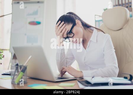 Forte mal di testa. Stanco avvocato di signora di affari malato con grimace forte di emicrania. Indossa il formalwear, siede in ufficio, toccandola in avanti Foto Stock