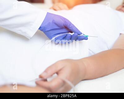 Un medico con un ago e le attrezzature necessarie per prelevare il sangue da un paziente che ha subito il coronavirus. Il concetto di trattamento con antibo Foto Stock