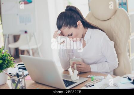 Influenza sul lavoro. Stanco avvocato di signora di affari malato con grimace forte di emicrania. Indossa il foralwear, seduto in ufficio, tocca la fronte Foto Stock