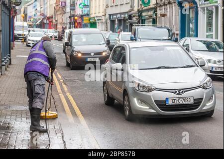 Bandon, West Cork, Irlanda. 18 maggio 2020. Bandon ha fatto pulire la strada principale questa mattina, come parte della fase di 'ritorno al business' di uscire dal blocco Covid-19, Soft Clean Group è stato incaricato di eseguire il compito a Bandon. Robert Healy, un dipendente, pulisce la strada con un panno morbido. Credit: Notizie dal vivo di AG/Alamy Foto Stock