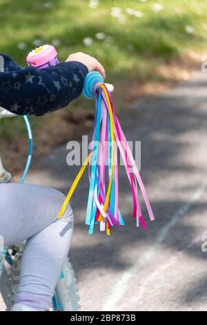 una vista ravvicinata di taselli colorati attaccati ad una bici delle bambine Foto Stock
