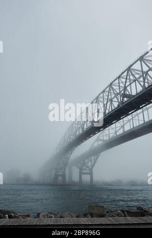 Nebbia che circonda la doppia campata di ponti sul fiume. Percorso che porta a un futuro sconosciuto di uscire dalla nebbia. Foto Stock