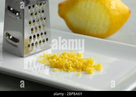 Scorza di limone fresca e grattugia da vicino Foto Stock