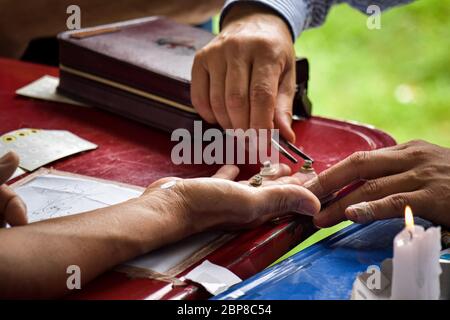 Primo piano di mano del cassiere di fortuna. Guarigione antica Foto Stock