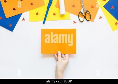 Come facile fare carta adorabile divertente pesce giocattolo con i bambini a casa. Istruzioni dettagliate. Mani che fanno la fabbricazione estiva fai da te. Vista dall'alto. Fase 1 Foto Stock