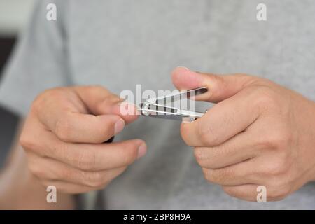 Uomo che taglia i chiodi con il tagliaunghie, primo piano Foto Stock