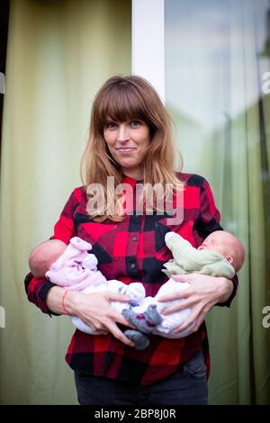 Una madre che porta i suoi gemelli neonatali maschi e femmine, Londra. Foto © Sam Mellish Foto Stock