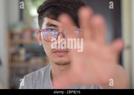 Primo piano di un giovane asiatico che si avvicina. Mano sfocata Foto Stock