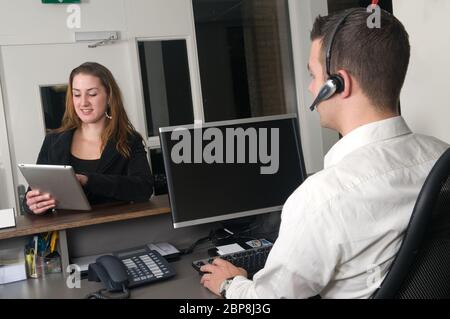 Il cliente ottenere alcune informazioni a un service desk Foto Stock