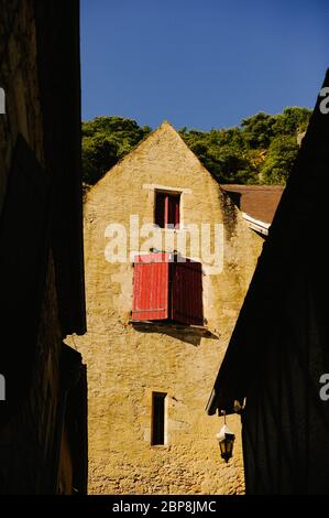 Una porta rossa in alto su un edificio uno dei più bei villaggi in Francia la Roque-Gageac in estate sera sole – Foto data Sabato 31 J Foto Stock