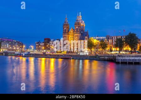 Di notte la vista panoramica della cittã di Amsterdam canal, il ponte e la Basilica di San Nicola, Holland, Paesi Bassi. Lunga esposizione. Foto Stock