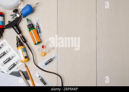 Kit professionale tatuaggio su tavolo in legno bianco Foto Stock