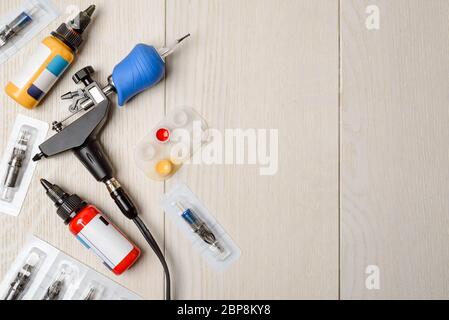 Macchina tatuatrice, inchiostro e aghi su tavola di legno Foto Stock