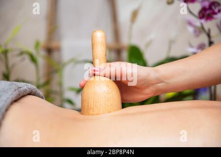 Donna che ha massaggio di maderoterapia posteriore con tazza svedese di legno Foto Stock