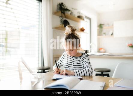 Bambina che impara in casa, virus Corona e concetto di quarantena. Foto Stock