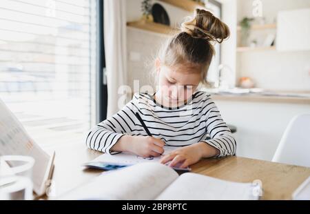 Bambina che impara in casa, virus Corona e concetto di quarantena. Foto Stock