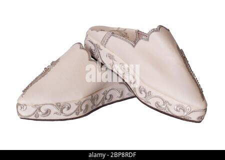 Pantofole donna isolato. Guardaroba di eleganti e lussuosi pantofole beige fatte a mano con splendidi ricami floreali e strass. Alla moda Foto Stock