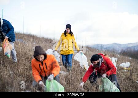 Gruppo di attivisti che raccolgono la lettiera in natura, concetto di inquinamento ambientale. Foto Stock