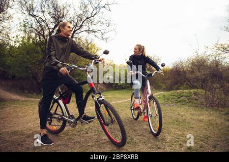 I migliori amici che si divertono vicino al parco di campagna, a cavallo delle biciclette, trascorrere del tempo in salute. Calma natura, primavera giorno, emozioni positive. Attività sportive e attive per il tempo libero. Viaggiare o camminare insieme. Foto Stock