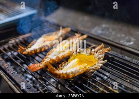 3 Grandi gamberi grigliare sulla griglia. Fumo di notte. Preferite il cibo tailandese. Messa a fuoco selettiva. Foto Stock