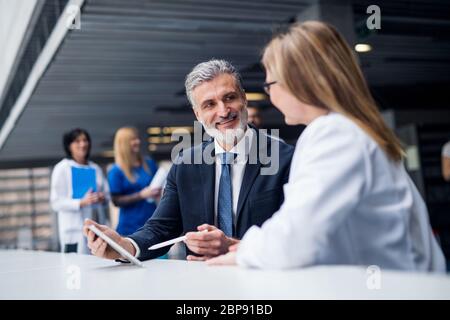 Medico che parla con un rappresentante di vendita farmaceutico. Foto Stock