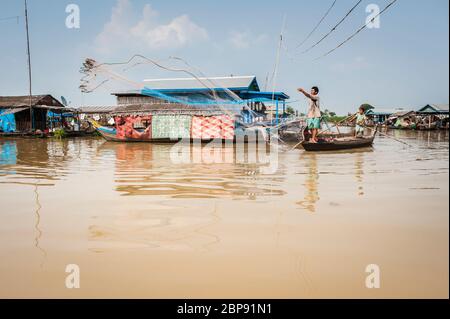 Un pescatore getta la sua rete nel villaggio galleggiante a Kompong Chnnang, Krong Kampong Chhnang, Cambogia, Sud-est asiatico Foto Stock