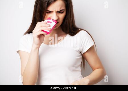 La donna graziosa usa un epilatore per rimuovere i capelli Foto Stock