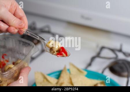 Aggiunta di antipasti a fungo di corn chips per rendere nachos Foto Stock