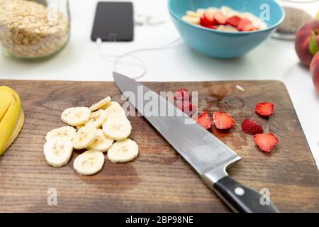 Una sana prima colazione fitness preparazione: fiocchi d'avena con banane, fragole e semi di Chia Foto Stock