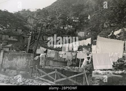 Fotografia d'epoca, lavoratori che costruiscono un muro di mattoni con case di quartiere e lavanderia su una linea a Corcovado, Rio de Janeiro, Brasile. Foto scattata il 12-13 luglio 1955 da un passeggero debarato da una nave da crociera. FONTE: FOTOGRAFIA ORIGINALE Foto Stock