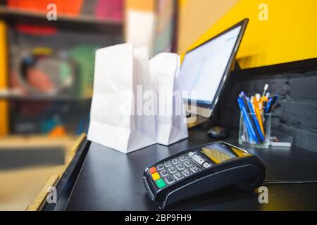 Terminale di pagamento su un tavolo, vista ravvicinata. Terminal POS presso la cassa di un negozio al dettaglio, concetto di business locale Foto Stock