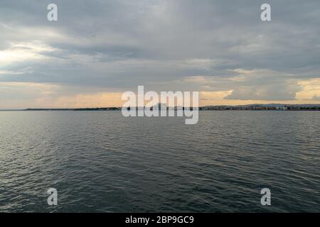 Seascape. Sera cielo nuvoloso e i raggi del sole. Vista sul mare città di Pomorie. La Bulgaria. Foto Stock