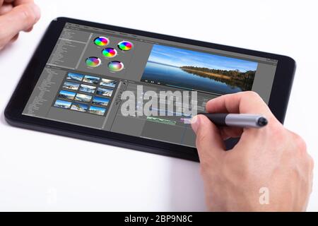 Giovane maschio editor di video editing su tablet al lavoro Foto Stock